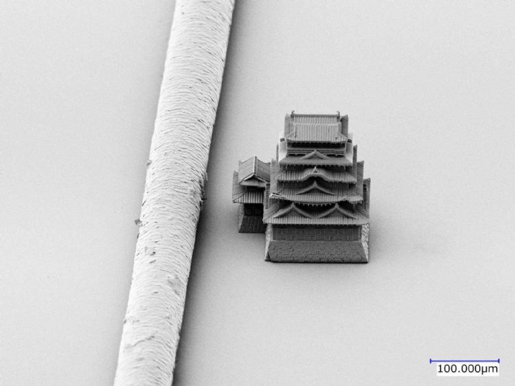 为宣扬自身定制化精密3D打印技术,Castem制造世界最小的城池模型。图为福山城模型(右)与头发(左)的对比照片。Castem
