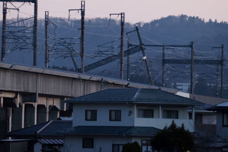 日本地震损坏电厂影响供电，但日方能先警报而非分区限电或跳电，对经济伤害较低，台湾应参考。图为日本地震及受损的输电线路。法新社